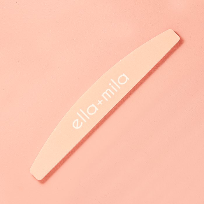 Peach half-moon nail file on a peach background