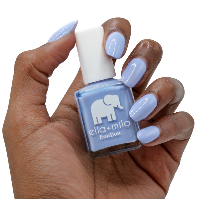 Life's a Beach periwinkle blue nail polish on a deep skin tone, hand holding the bottle